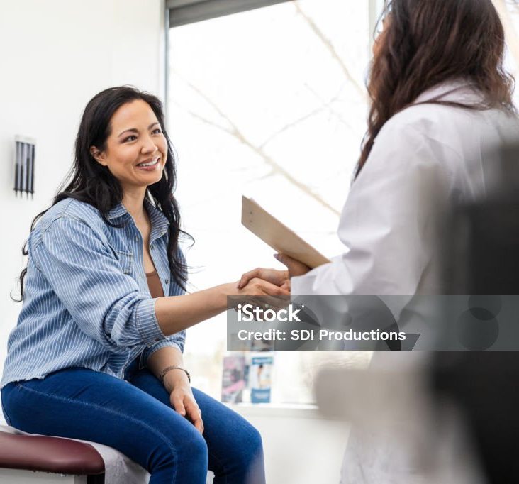 Arriving for her appointment, the unrecognizable female doctor shakes hands with her patient.